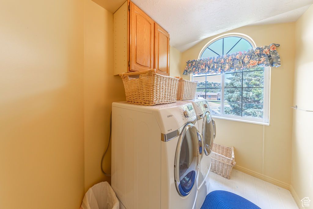 Laundry area featuring cabinet space and washing machine and clothes dryer