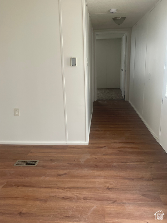Corridor featuring wood finished floors and baseboards