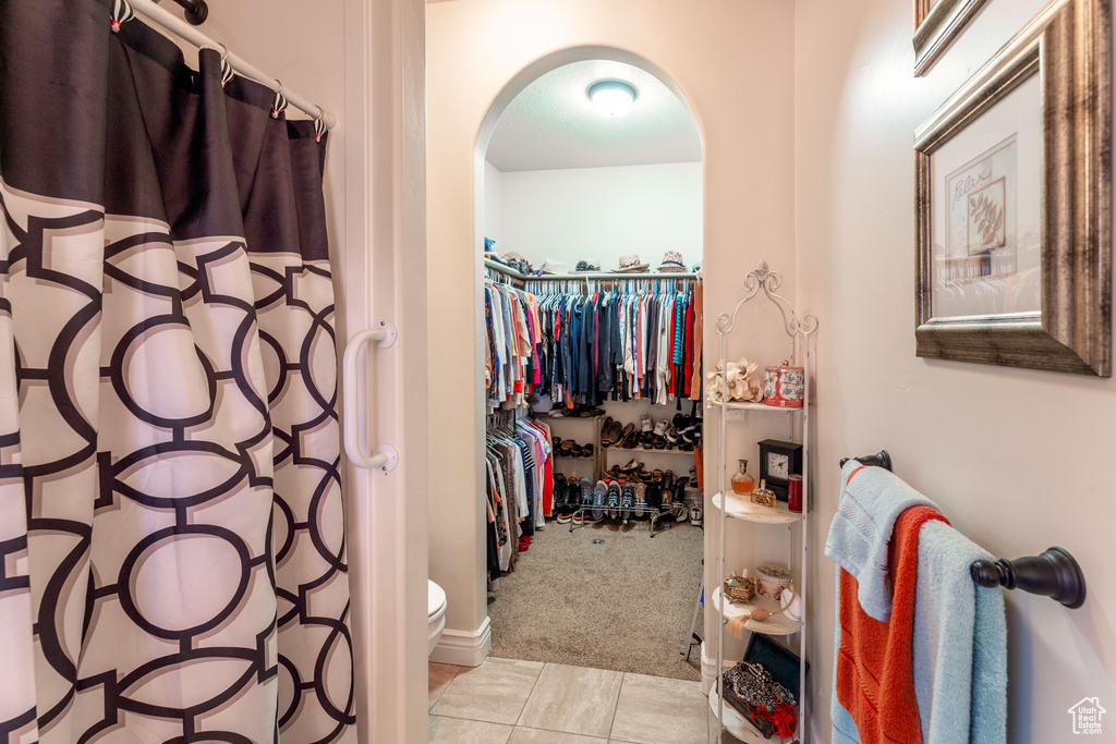Full bathroom with tile patterned flooring, a spacious closet, and curtained shower