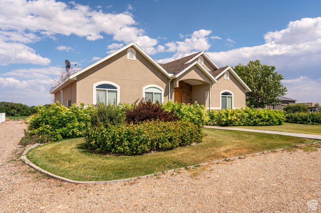 View of front of house featuring stucco siding and a front lawn