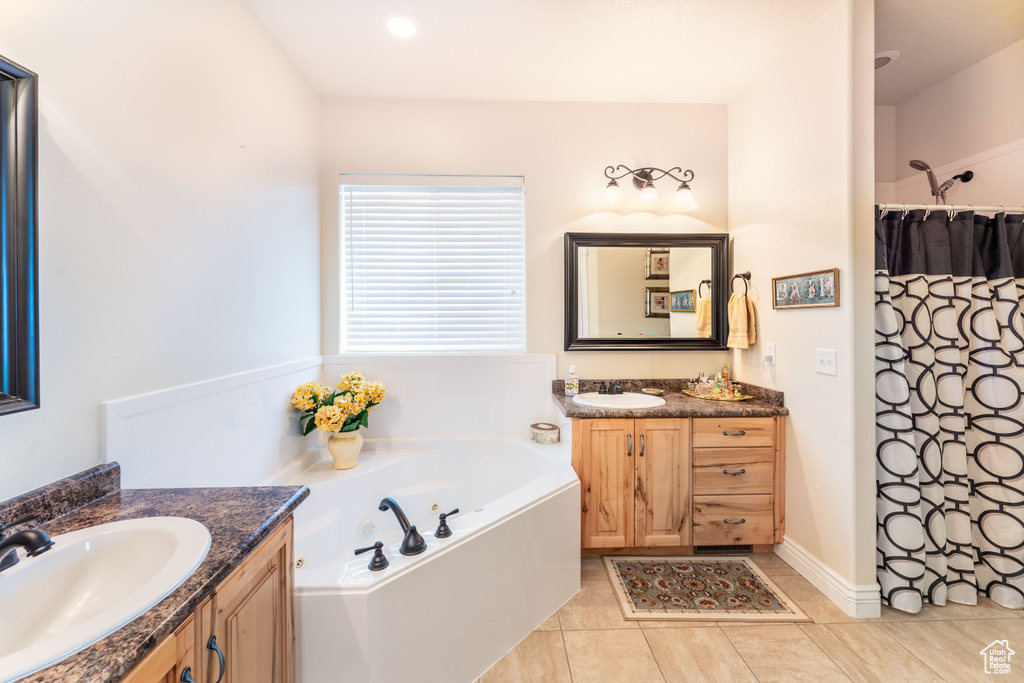 Bathroom featuring two vanities, a garden tub, tile patterned floors, and a shower with shower curtain