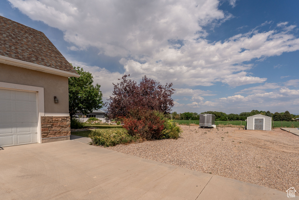 View of yard featuring a storage shed and a garage