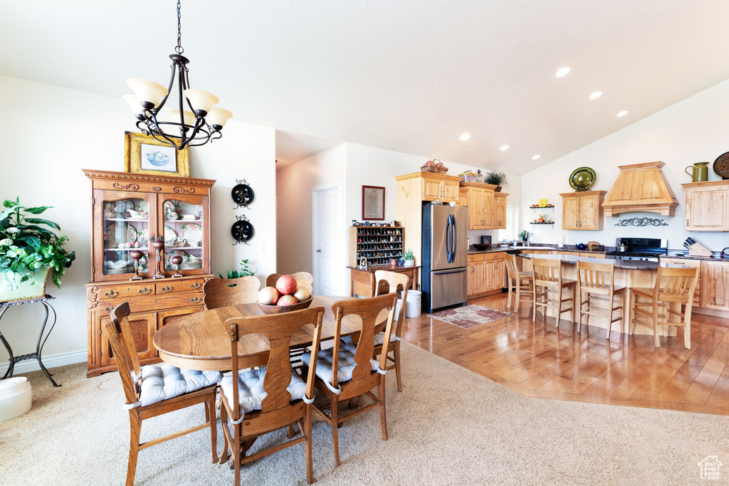 Dining room featuring a chandelier, light carpet, recessed lighting, and lofted ceiling