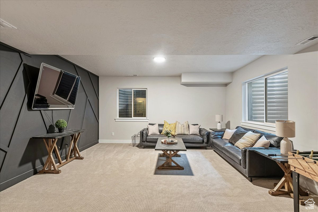 Living area with light carpet and a textured ceiling