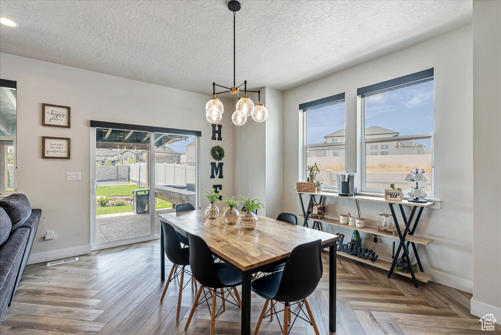 Dining space featuring healthy amount of natural light, a textured ceiling, and recessed lighting