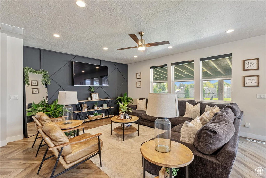Living room featuring ceiling fan, a textured ceiling, and recessed lighting