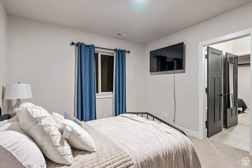 Bedroom featuring light carpet and baseboards