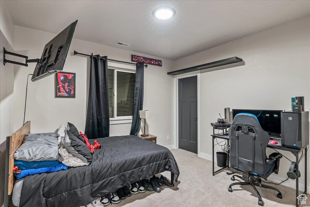 Bedroom with carpet flooring and an office area