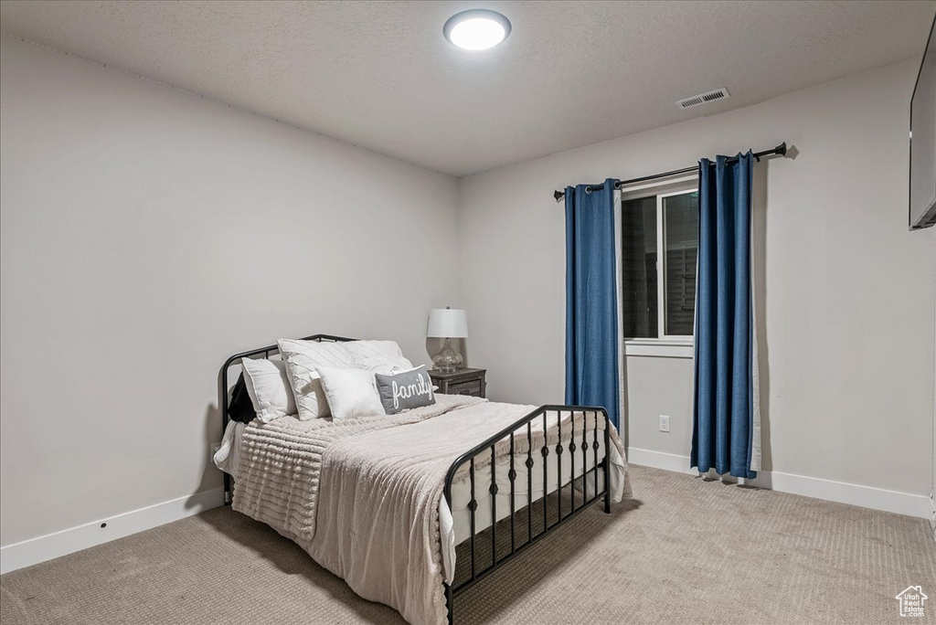 Bedroom featuring light carpet and baseboards