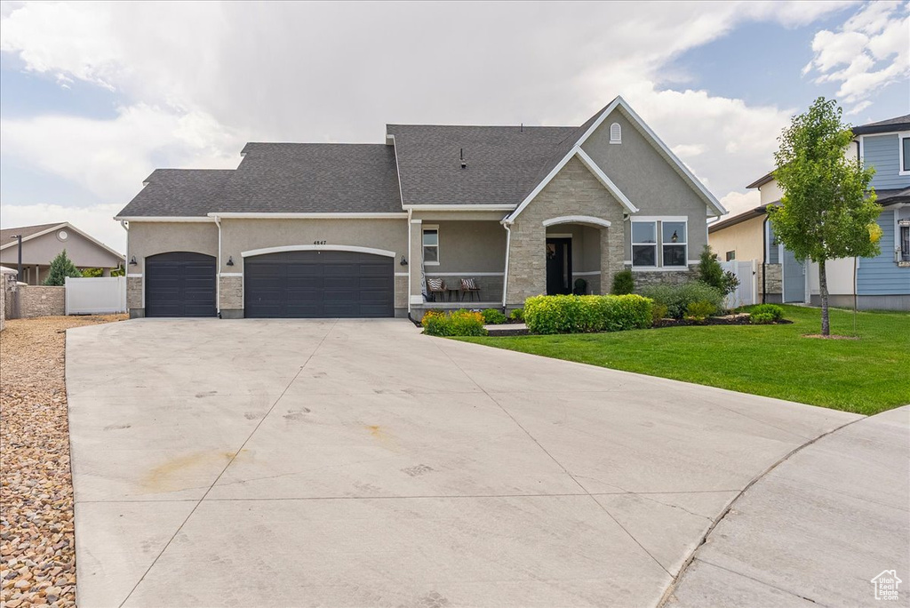 View of front of home featuring stucco siding, stone siding, an attached garage, driveway, and a shingled roof
