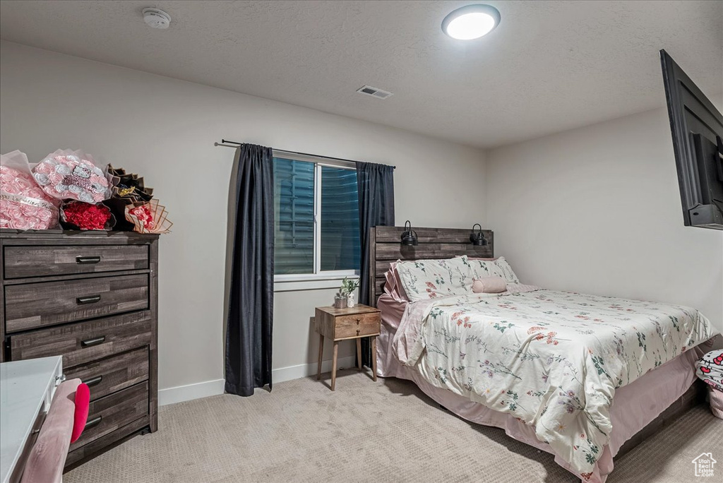 Bedroom featuring light carpet and baseboards
