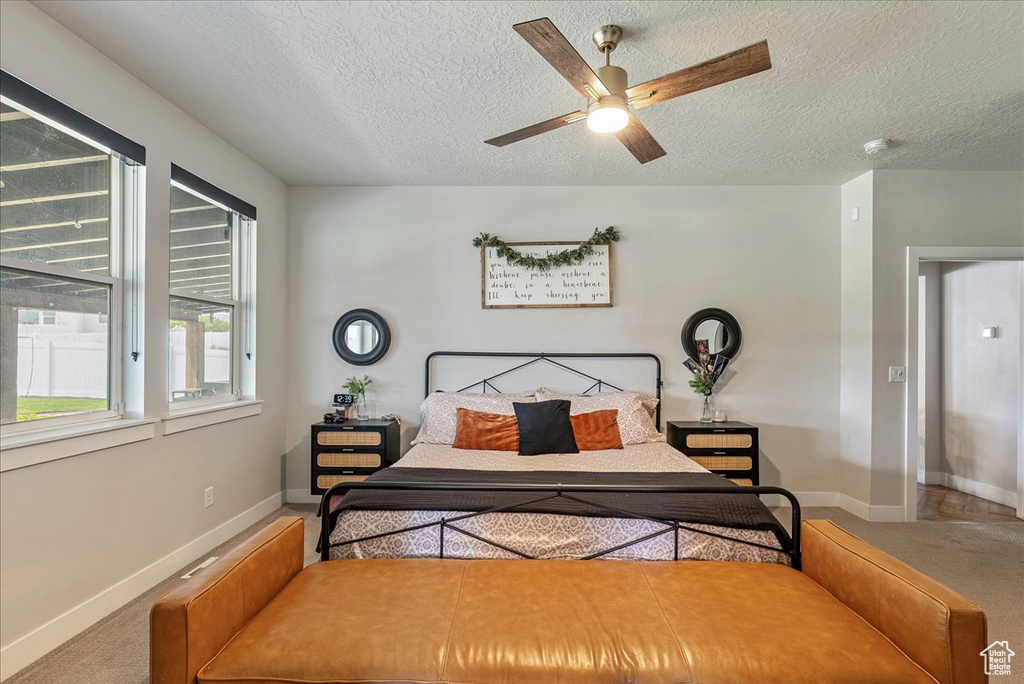 Bedroom with a textured ceiling and ceiling fan