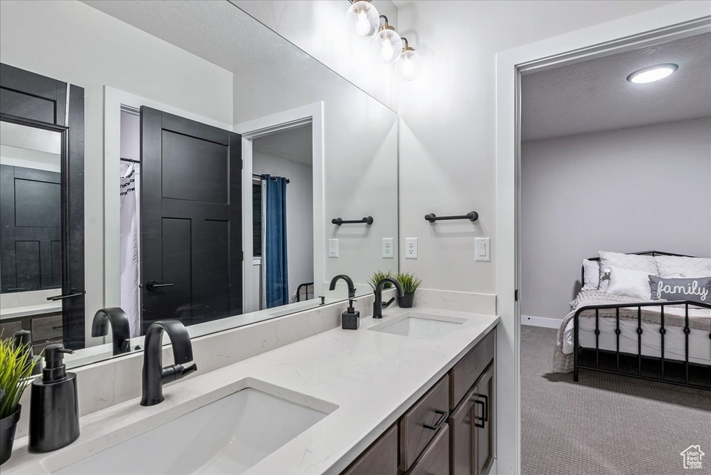 Full bathroom featuring double vanity and baseboards