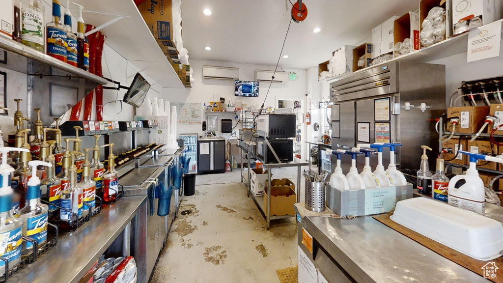 Misc room featuring unfinished concrete flooring, an AC wall unit, and recessed lighting