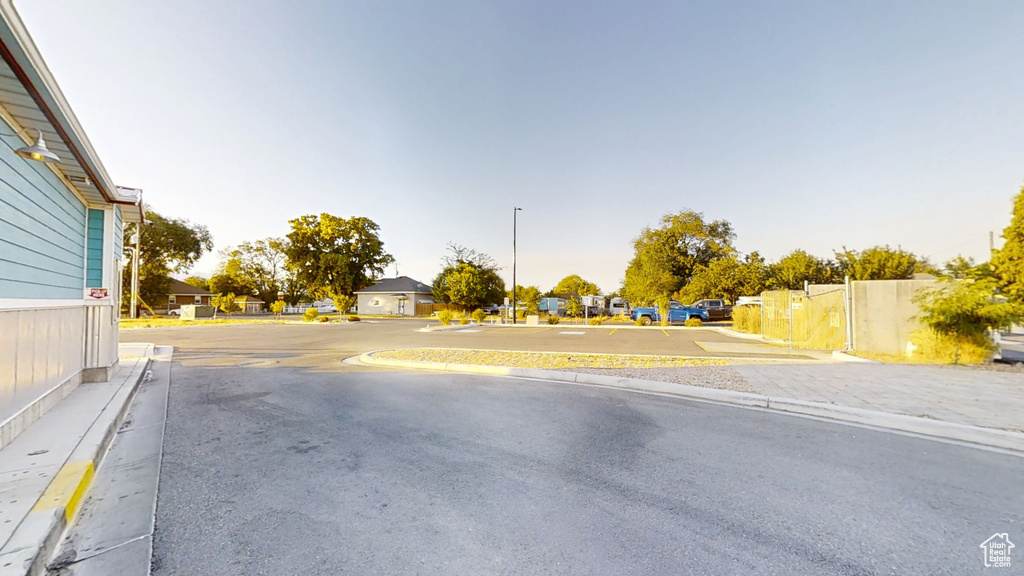 View of asphalt street featuring curbs, a residential view, and sidewalks