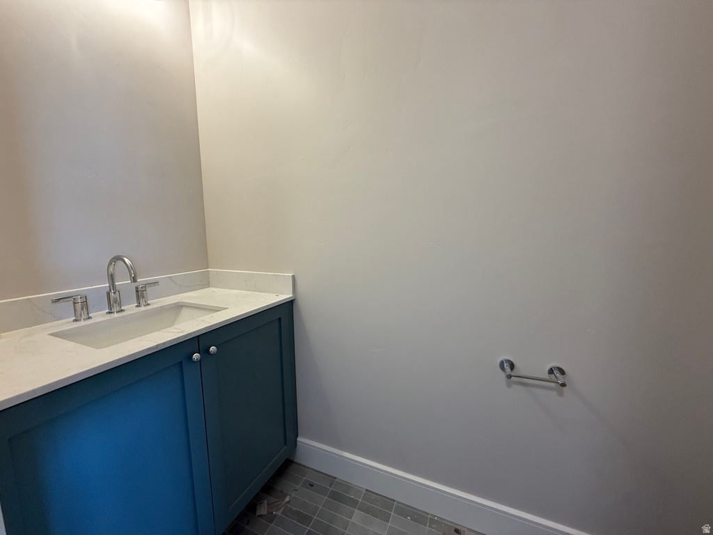 Bathroom featuring vanity and dark tile patterned floors