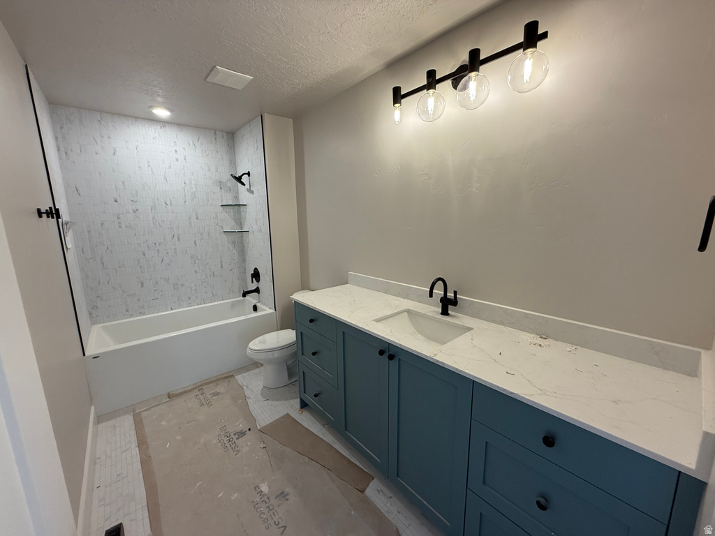 Full bath featuring vanity, washtub / shower combination, and a textured ceiling