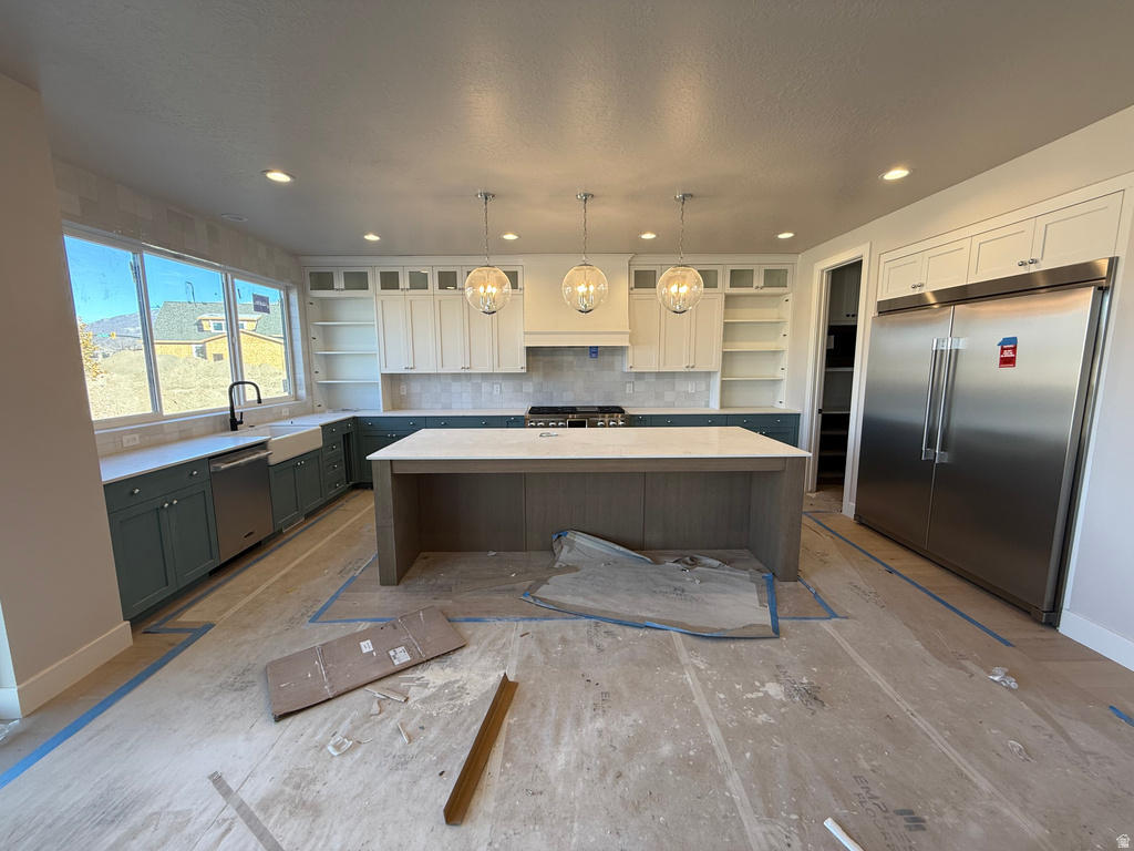 Kitchen featuring open shelves, a kitchen island, stainless steel appliances, white cabinets, and pendant lighting