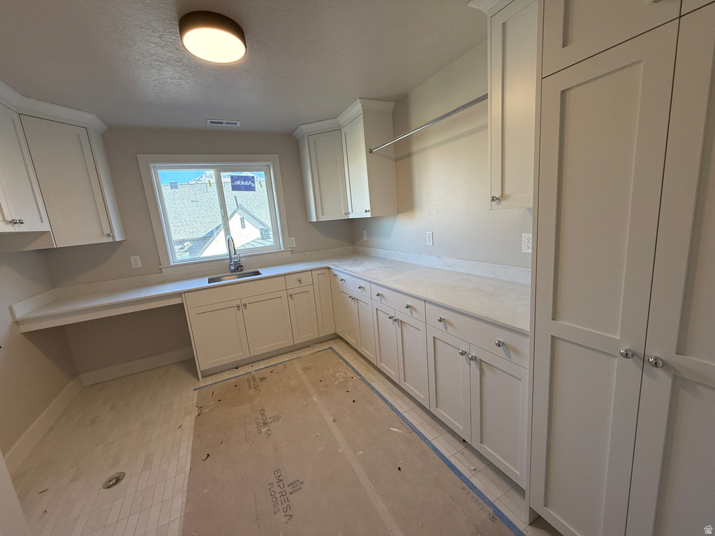 Kitchen featuring white cabinets and a textured ceiling