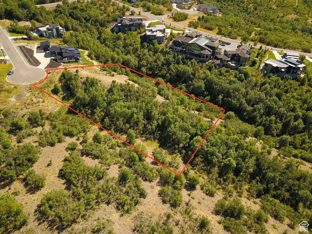Aerial view of property and surrounding area featuring property boundaries highlighted and a heavily wooded area