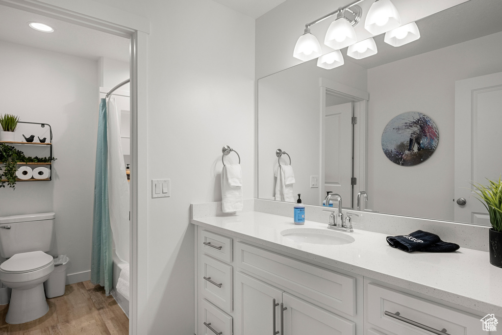 Full bath featuring light wood-type flooring, vanity, and shower / tub combo