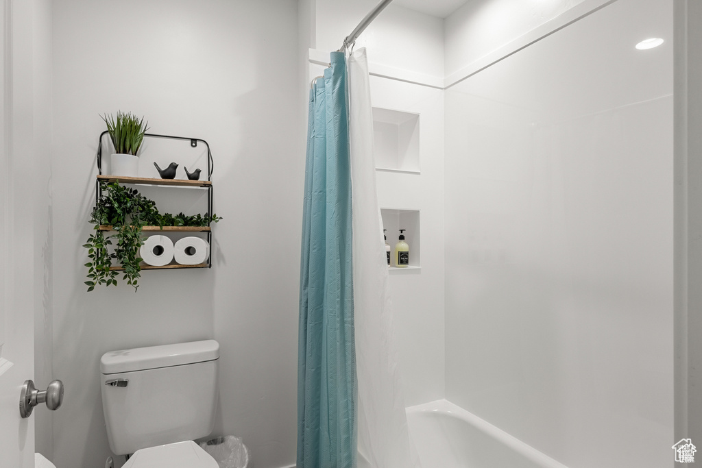 Bathroom with shower / bath combination with curtain and toilet