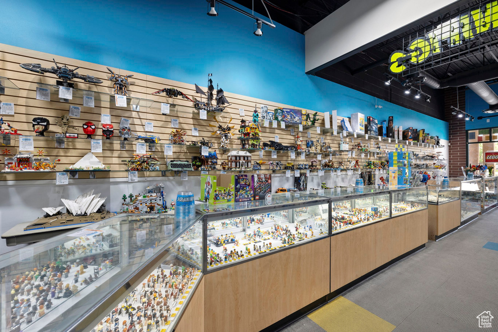 Community bar area with light brown cabinetry, track lighting, stone countertops, and modern cabinets