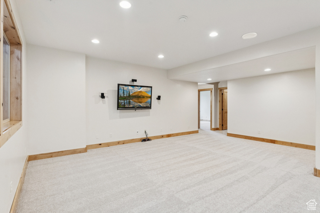 Finished basement with recessed lighting and light carpet