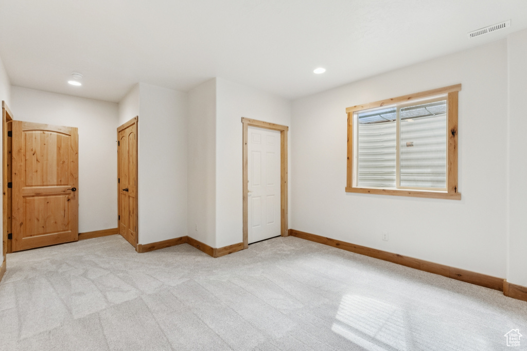 Unfurnished bedroom with light colored carpet, recessed lighting, and a closet