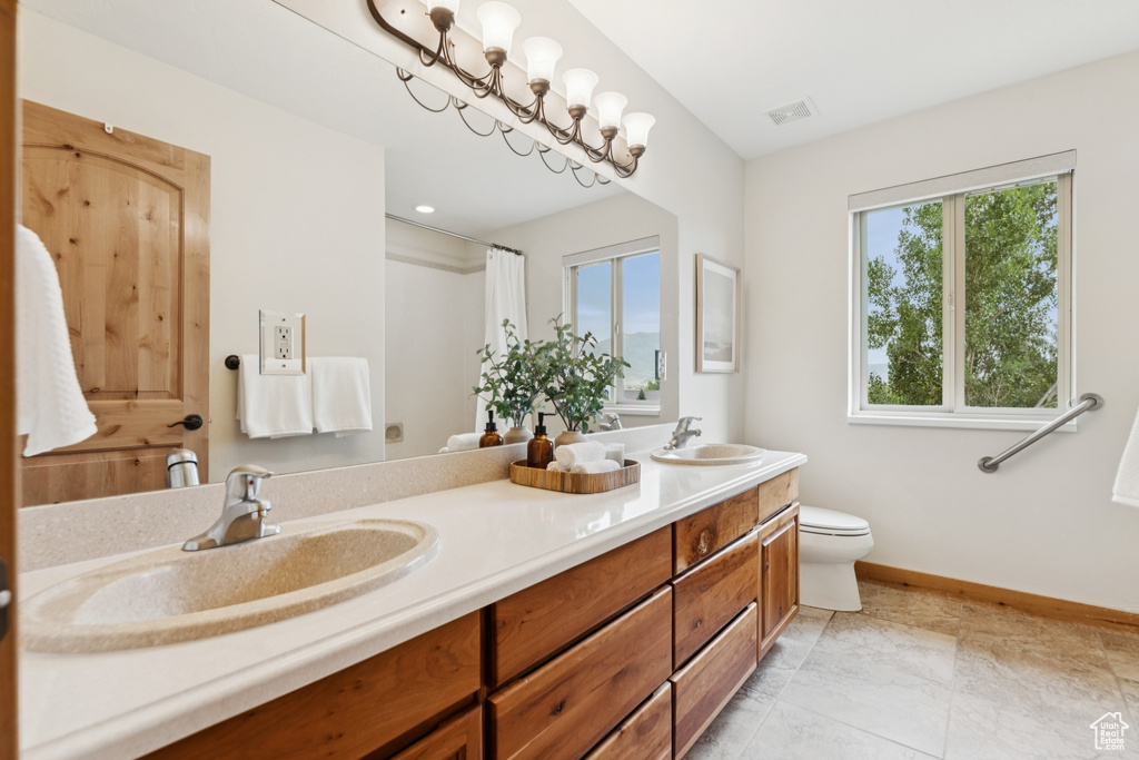 Full bathroom featuring double vanity, a shower with shower curtain, and light tile patterned flooring
