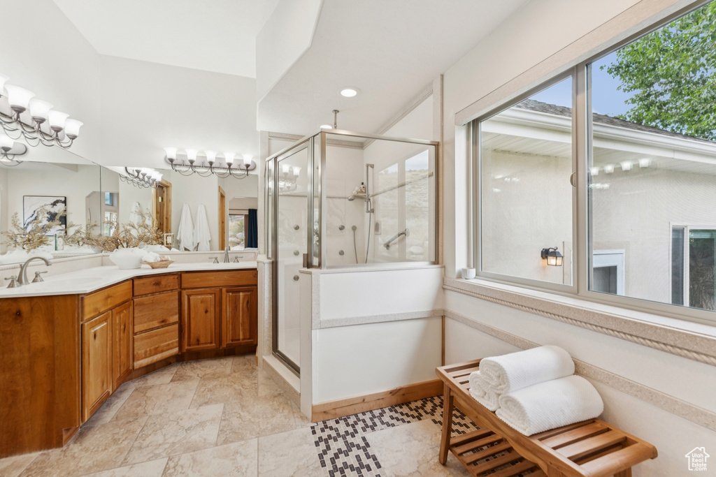 Bathroom with a shower stall, double vanity, and recessed lighting