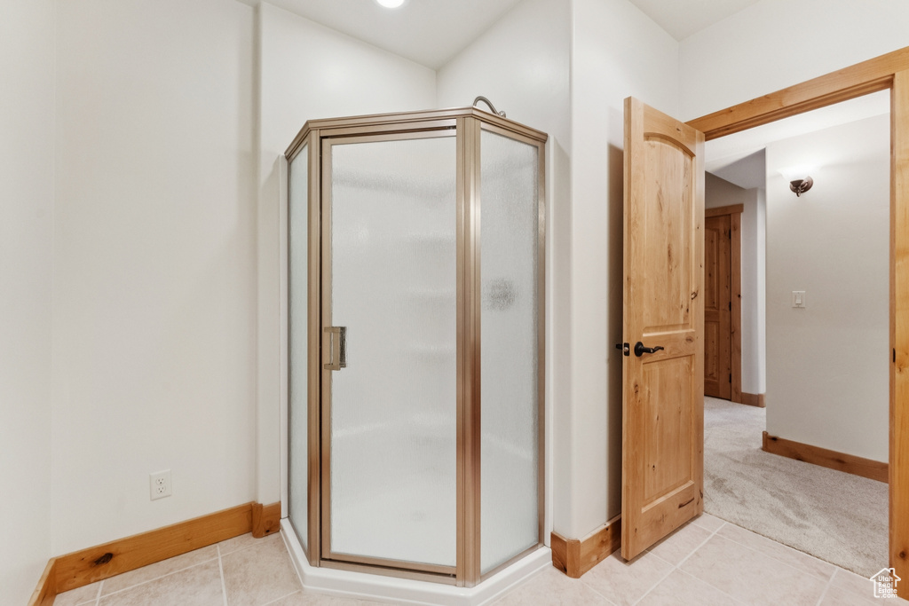 Full bath featuring a shower stall and light tile patterned floors
