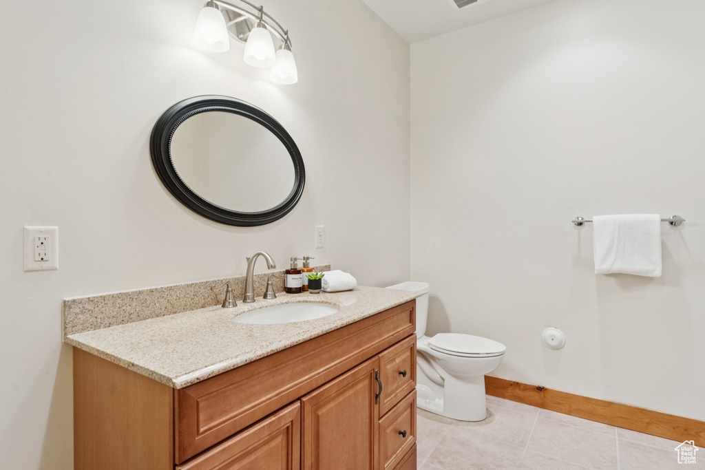 Half bathroom featuring vanity and light tile patterned flooring