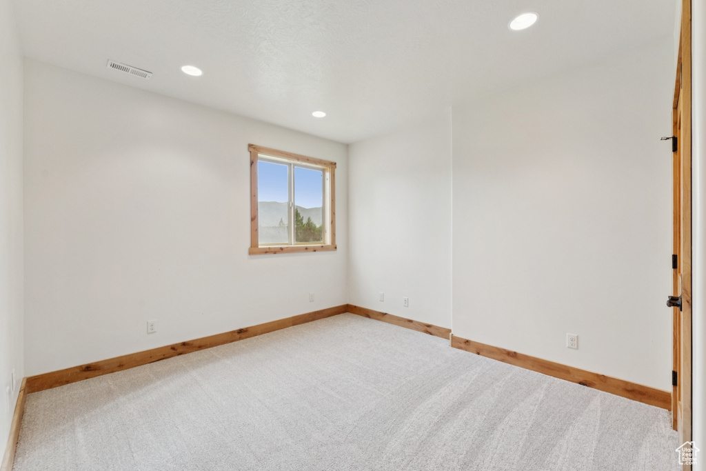 Empty room with carpet flooring and recessed lighting
