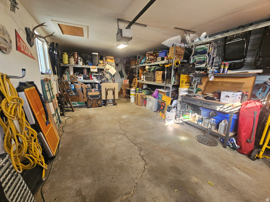 Garage featuring a workshop area and a garage door opener