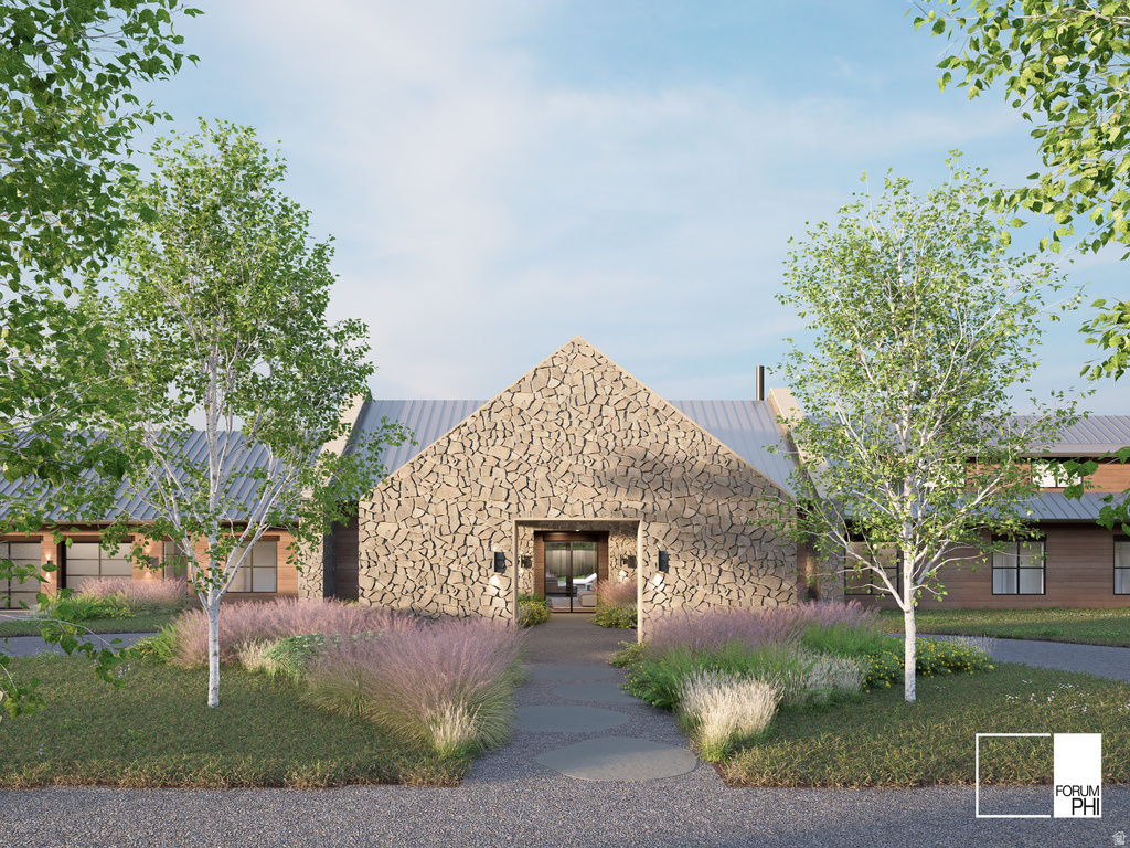 Stone facade entry with a pitched metal roof, flanked by mature trees and landscaped plantings