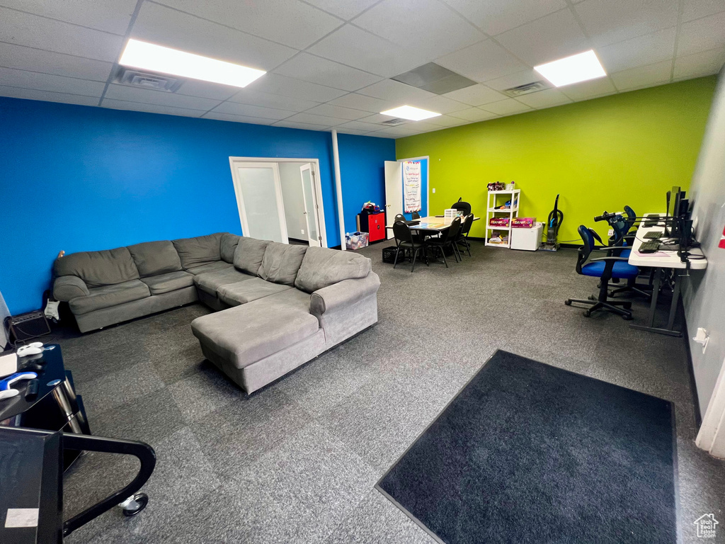Living area featuring a drop ceiling and baseboards