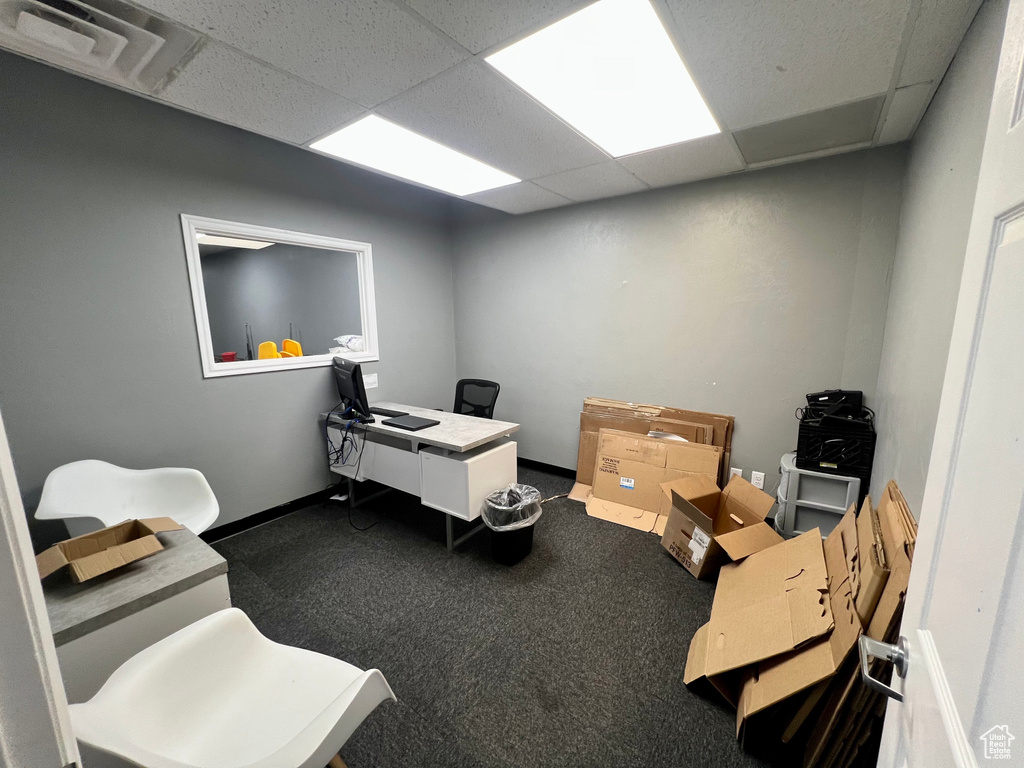 Office with a paneled ceiling and carpet flooring