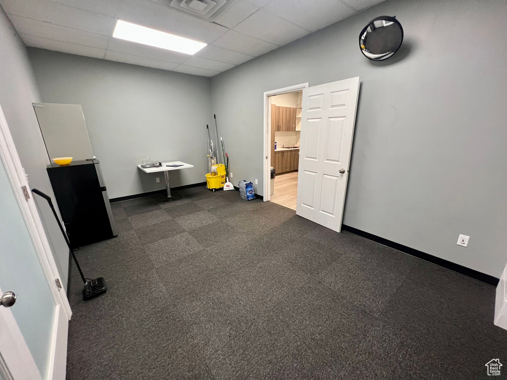 Miscellaneous room featuring a paneled ceiling and baseboards