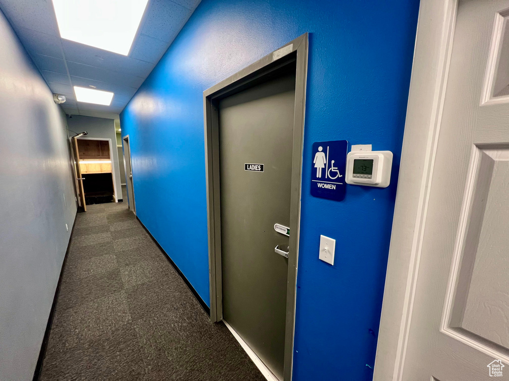 Corridor with dark carpet and baseboards