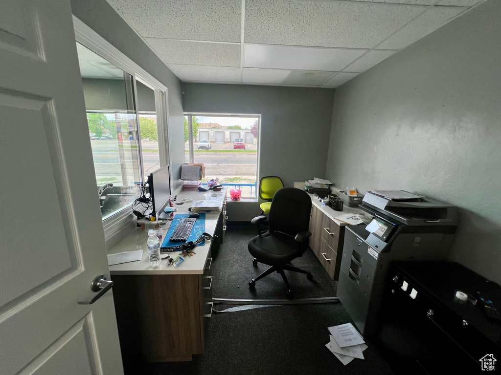 Office area with a paneled ceiling and dark carpet