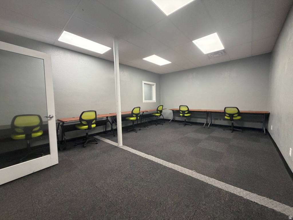 Spacious room featuring modular carpet tile flooring, a window, and recessed rectangular lighting