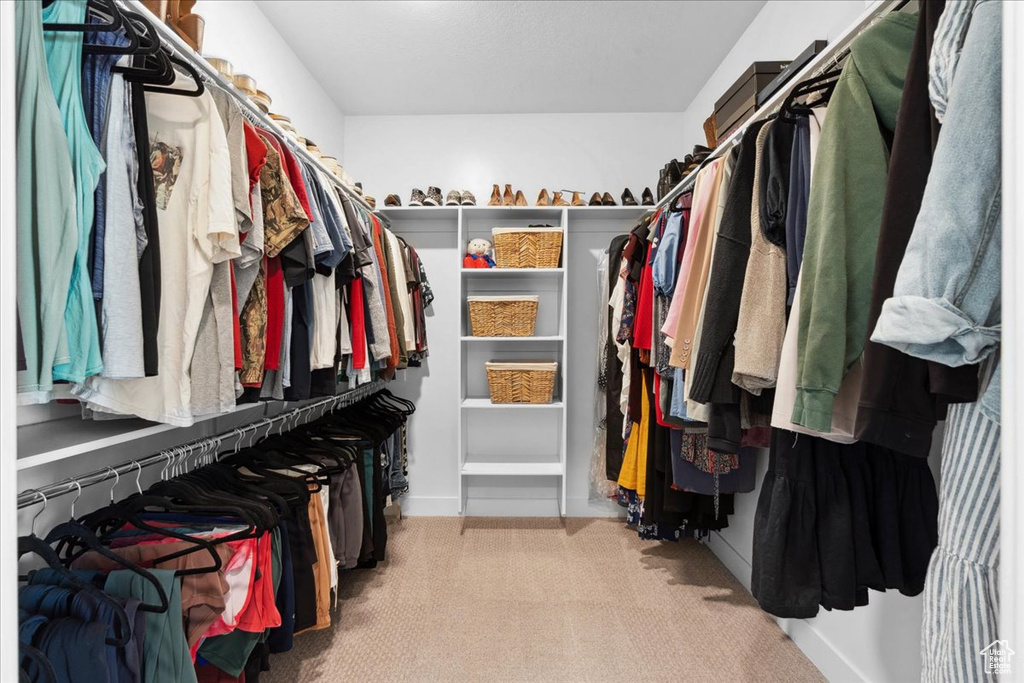 Walk in closet with light colored carpet