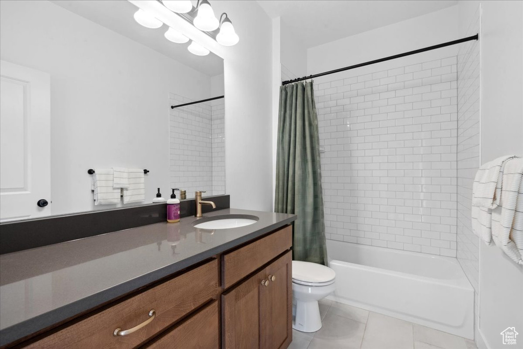 Bathroom featuring shower / tub combo with curtain, vanity, and light tile patterned floors
