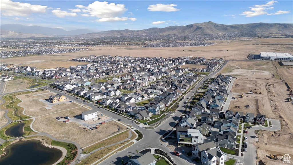 Aerial view of property and surrounding area with nearby suburban area and a mountain backdrop