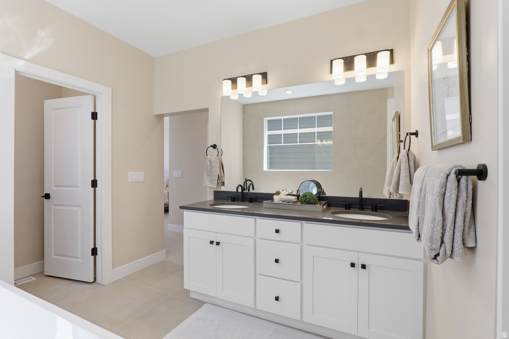 Dual vanity with white cabinetry, dark countertop, and matte black fixtures