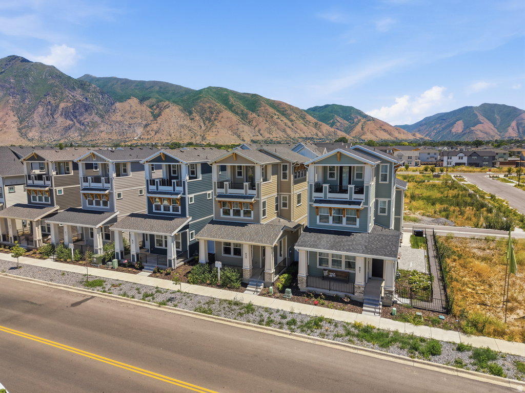 Contemporary multi-story townhomes featuring covered front porches, private balconies, and varied exterior siding colors