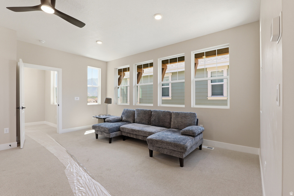 Carpeted room featuring a modern ceiling fan with integrated lighting, recessed lighting, and three large windows