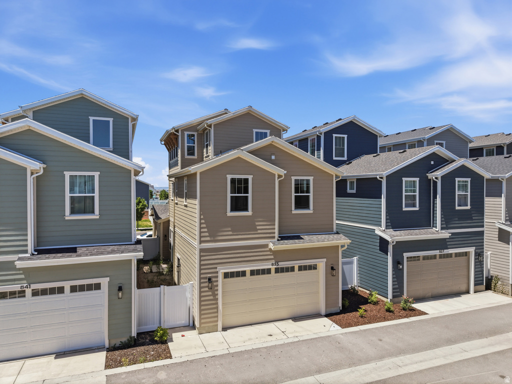 Contemporary residential exteriors featuring horizontal siding in varied earth tones and blues, white window trim, and attached garages