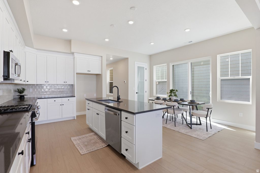 Modern kitchen featuring white cabinetry, dark countertops, and a subway tile backsplash